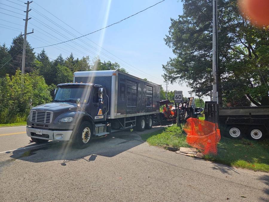 Apex Fibre crew truck working behind safety fencing on a government facility build